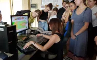 Grupa studentów obserwująca pracę kpbiety na komputerze we wzorcowni